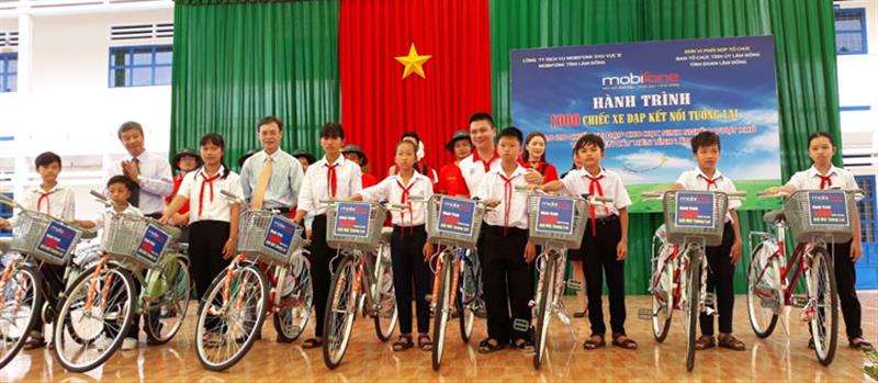 Trưởng Ban Tổ chức Tỉnh ủy Trần Duy Hùng và lãnh đạo huyện Cát Tiên, đại diện MobiFone tỉnh Lâm Đồng trao tặng xe đạp cho các em học sinh. Ảnh: NGÂN HẬU