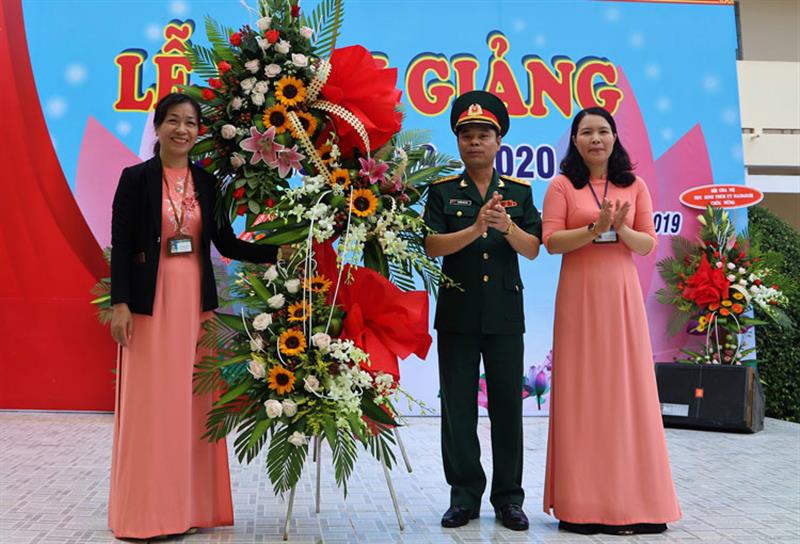 Đại tá Nguyễn Bình Sơn tặng hoa chúc mừng nhà trường. Ảnh: KHÁNH PHÚC
