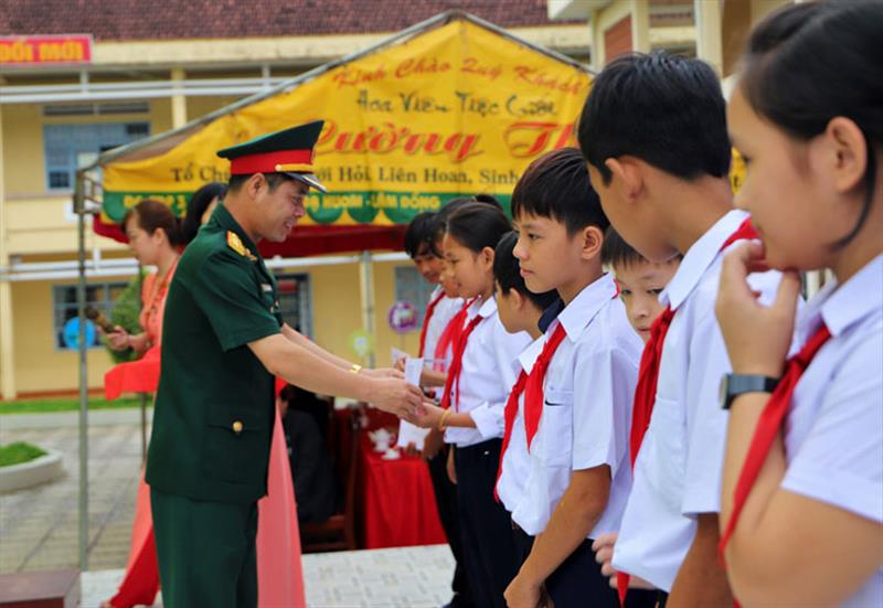 Đại tá Nguyễn Bình Sơn - UVBTV Tỉnh ủy, Chỉ huy trưởng Bộ Chỉ huy Quân sự tỉnh Lâm Đồng tặng học bổng cho các em học sinh nghèo. Ảnh: KHÁNH PHÚC