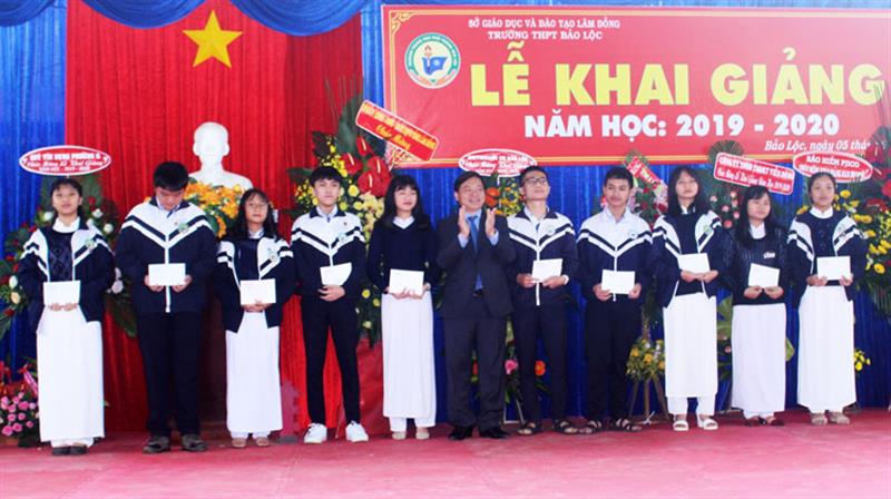 Đồng chí Nguyễn Văn Triệu trao học bổng cho các em học sinh nghèo vượt khó. Ảnh: KHÁNH PHÚC