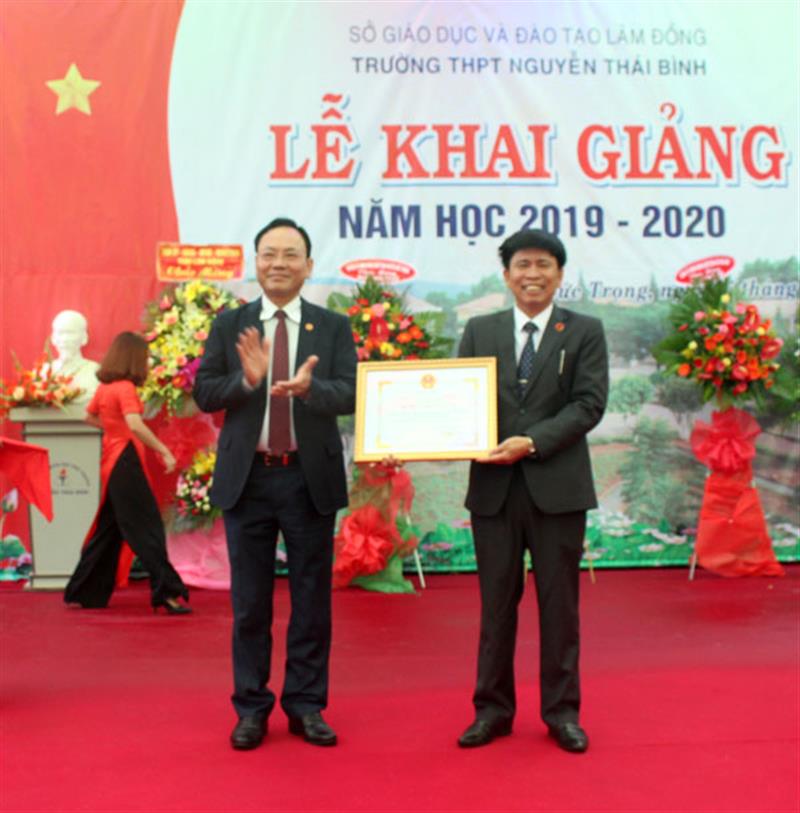 Đồng chí Nguyễn Văn Yên trao danh hiệu “Tập thể Lao động xuất sắc” năm học 2018 - 2019 cho lãnh đạo nhà trường. Ảnh: THY VŨ
