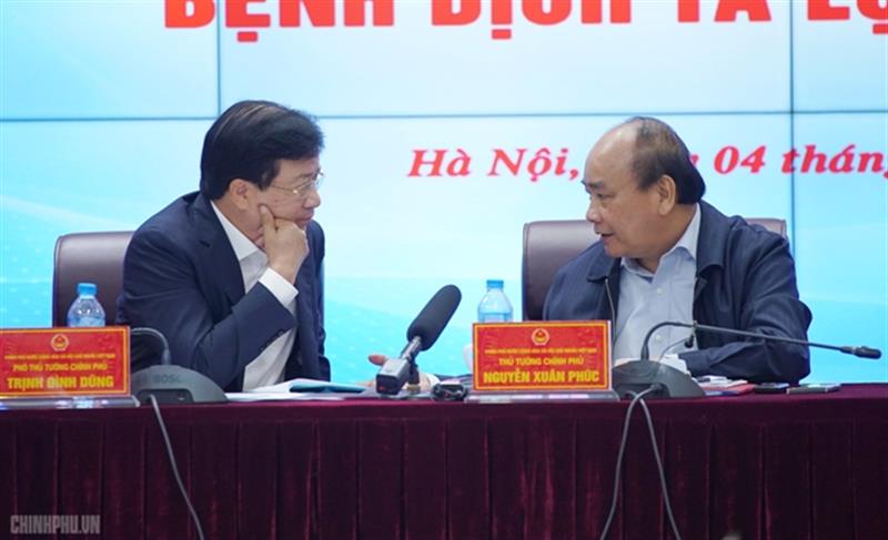 Thủ tướng Nguyễn Xuân Phúc trao đổi với Phó Thủ tướng Trịnh Đình Dũng. Ảnh VGP/Quang Hiếu